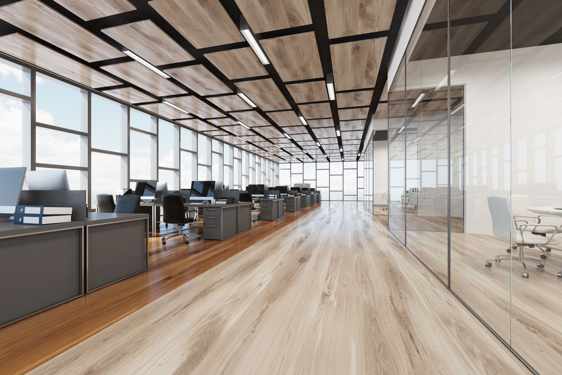 A large office with a lot of windows and wooden floors.