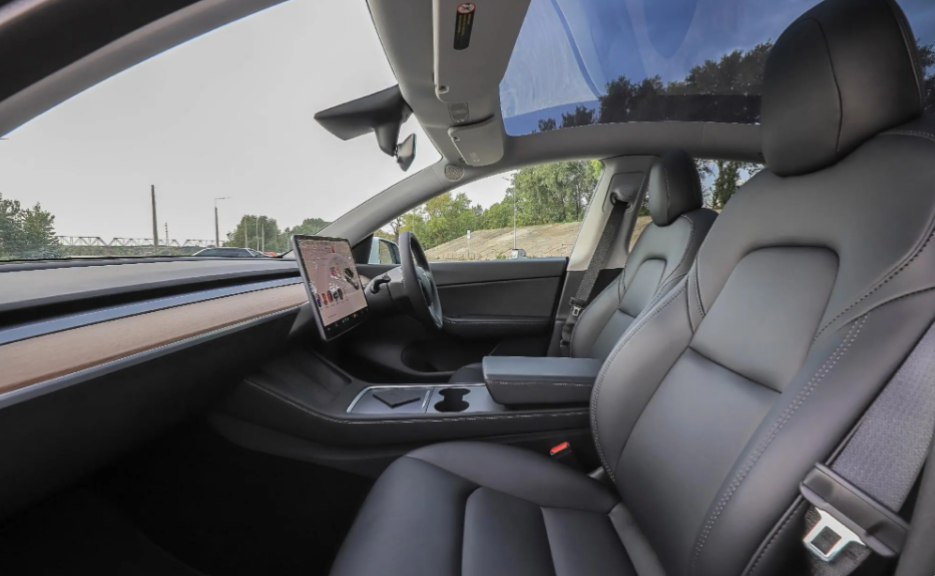 The interior of a car with a steering wheel and a shifter.