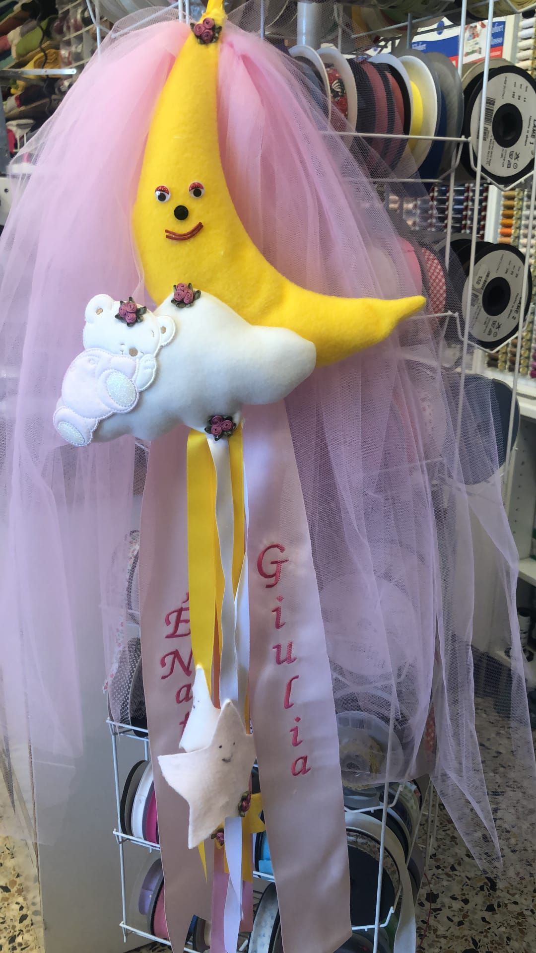 Una giostrina decorativa in feltro con una mezzaluna gialla e una nuvola bianca