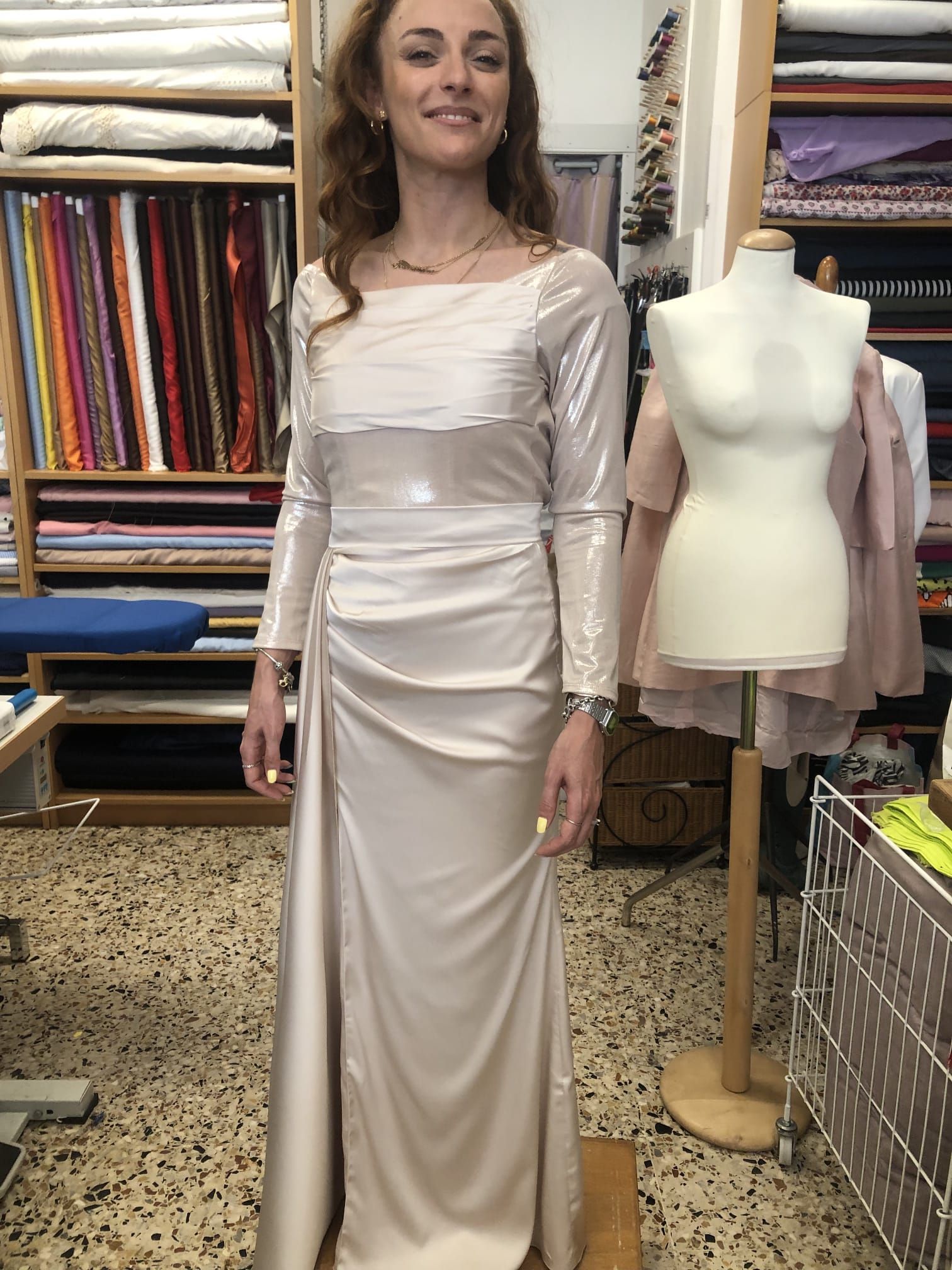 Banco di lavoro con fili, campionari tessili e strumenti di sartoria pronti per la lavorazione artigianale.