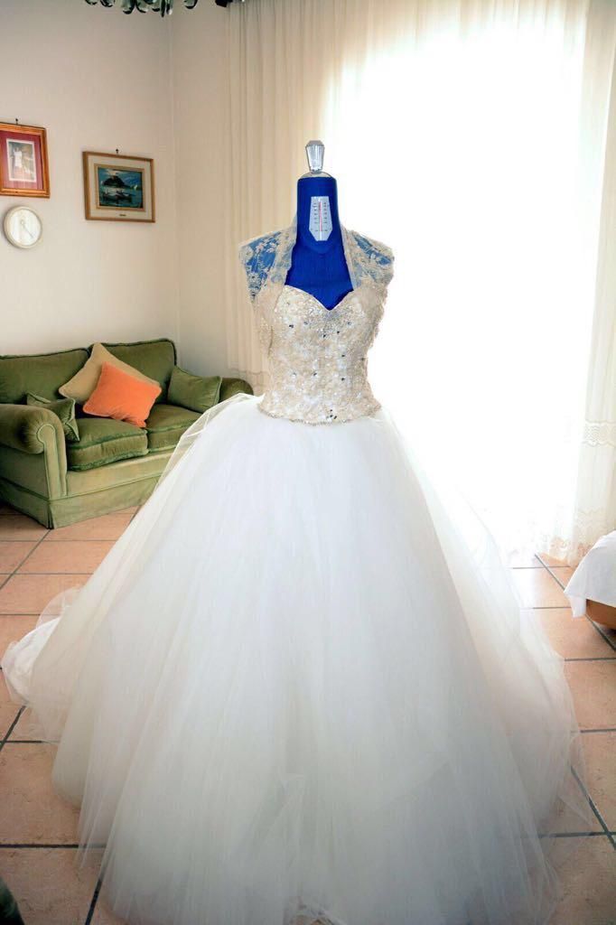 Interno del laboratorio Sartoria Luna con scaffali di filati, tessuti e strumenti artigianali ordinati con cura.