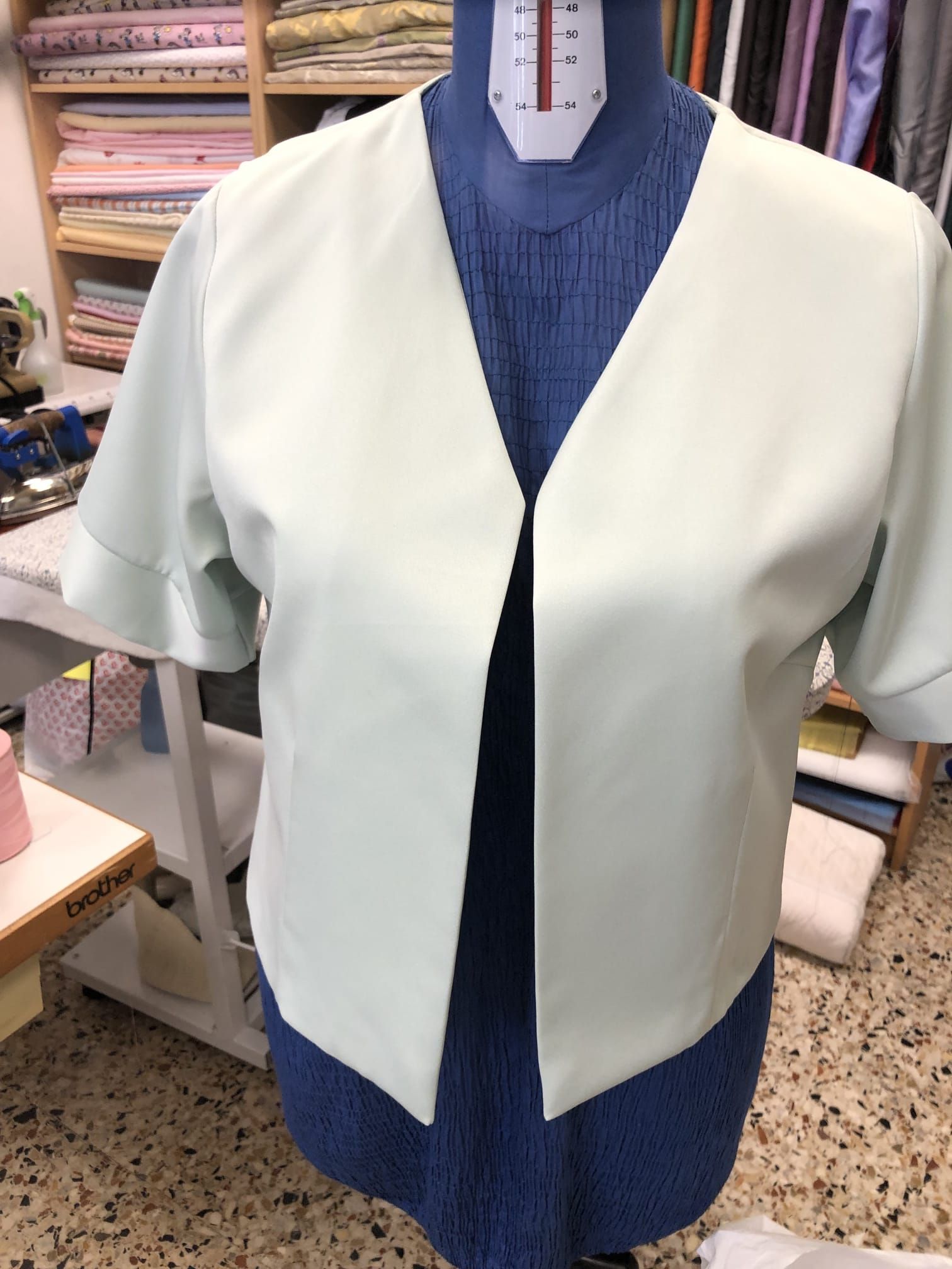 Strumenti da sartoria disposti su tessuto di lino.