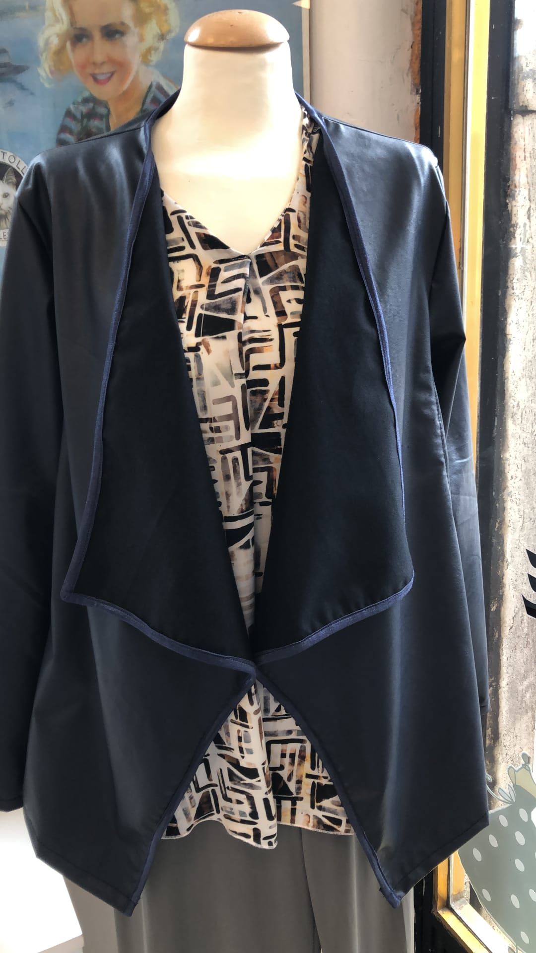 Interno ordinato del laboratorio con tessuti, fili e cassetti di merceria.