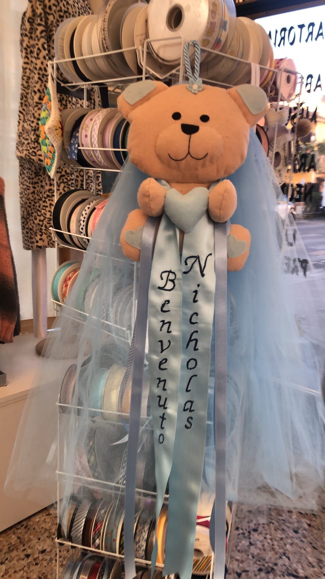 Un orsetto di peluche azzurro per un bambino di nome Nicholas, con un nastro su cui è scritto 