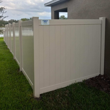 Beige vinyl fence around a grassy yard and house.