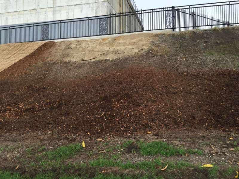 A Pile Of Dirt Is Sitting On Top Of A Hill Next To A Fence — Garden Maintenance And Mini Digger Hire In Mackay And Surrounds, QLD