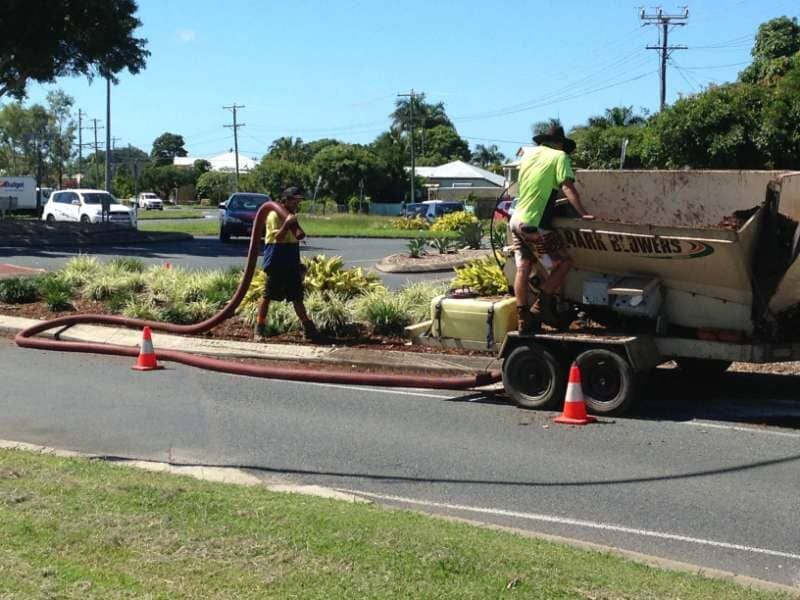 A Man Is Standing Next To A Truck That Has The Word Trucks On It — Mulch, Fencing And Landscaping Mackay, QLD