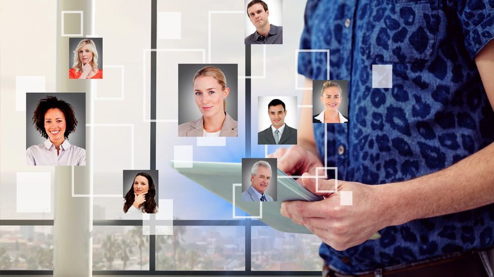 Persona que utiliza una tableta con fotos de perfil flotantes en una interfaz de red digital.