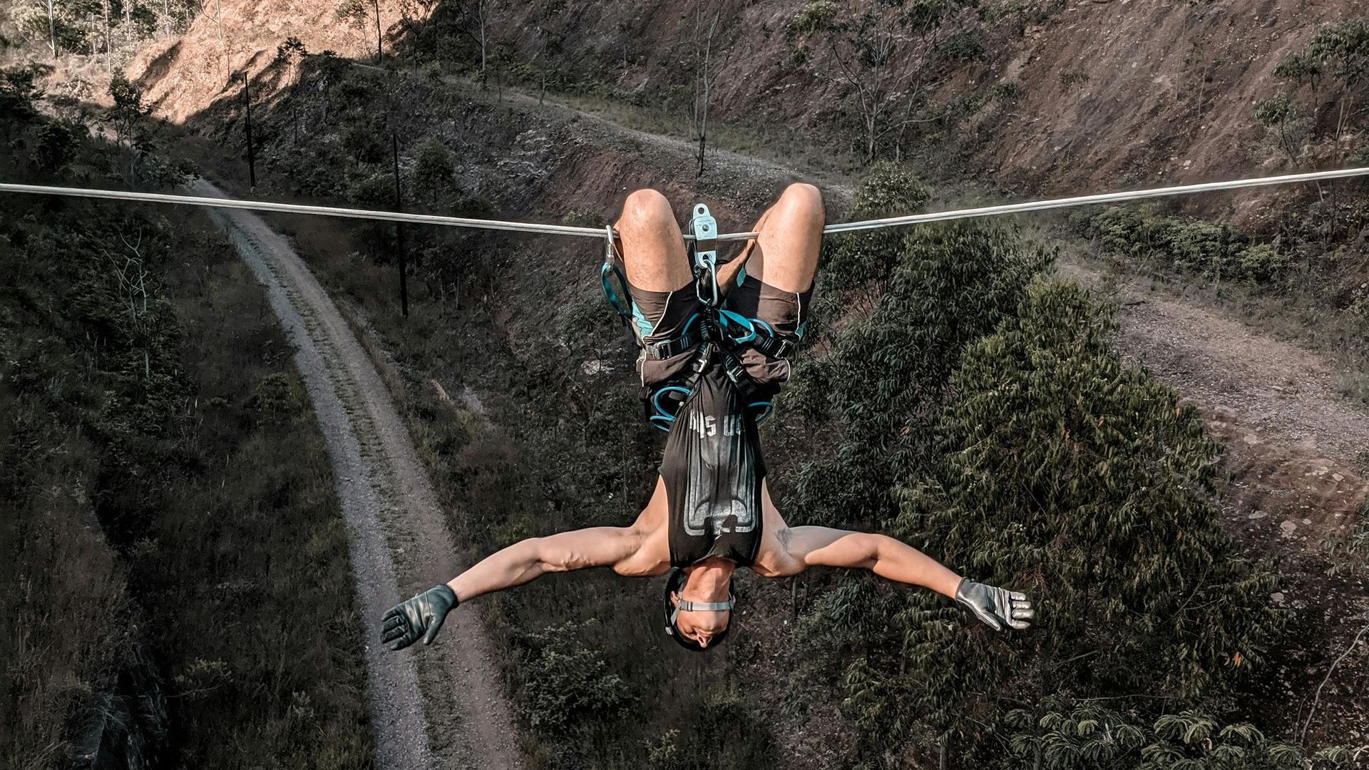 A woman is doing a handstand on a zip line.