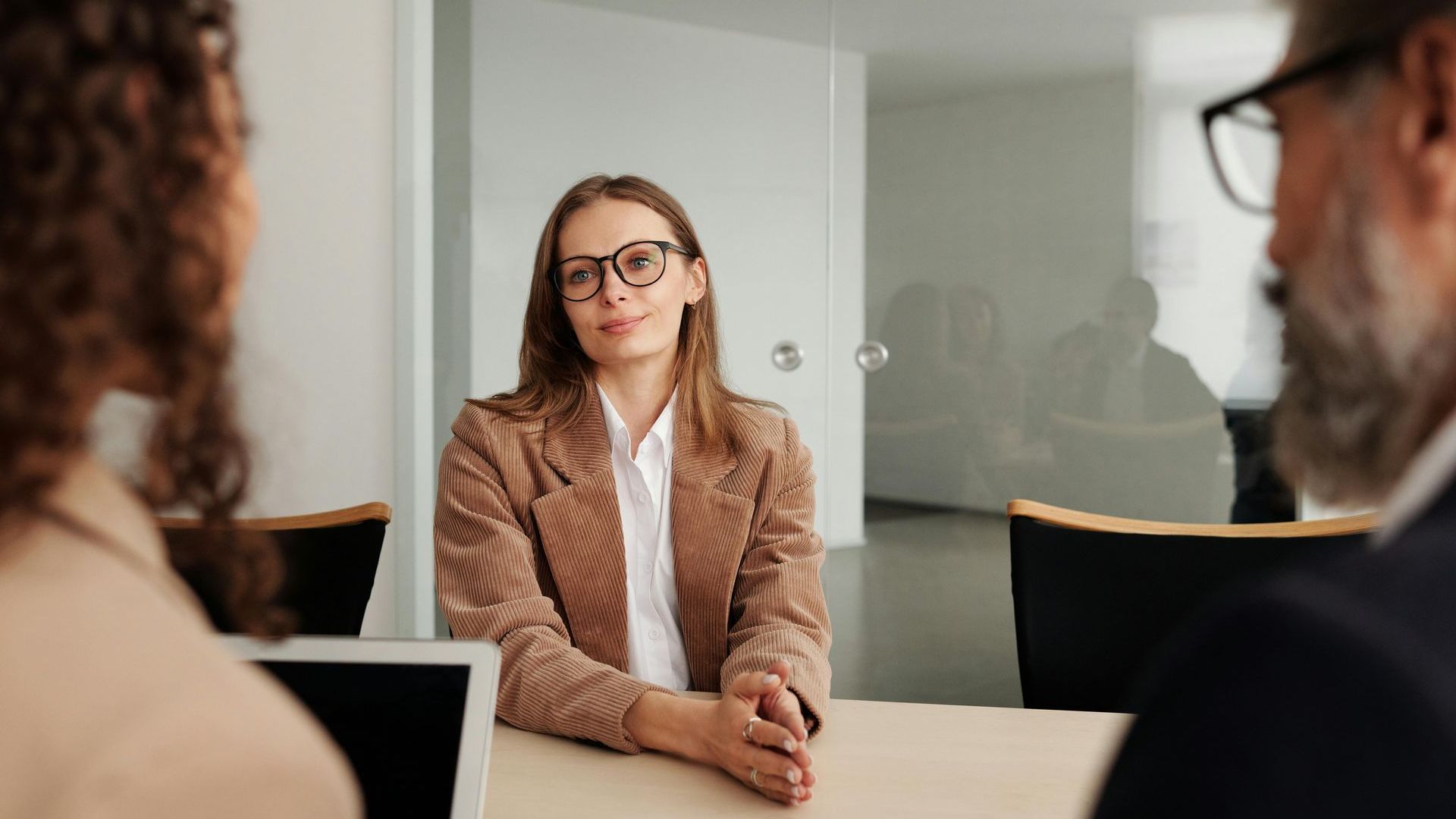 A woman is sitting at a table during a job interview.