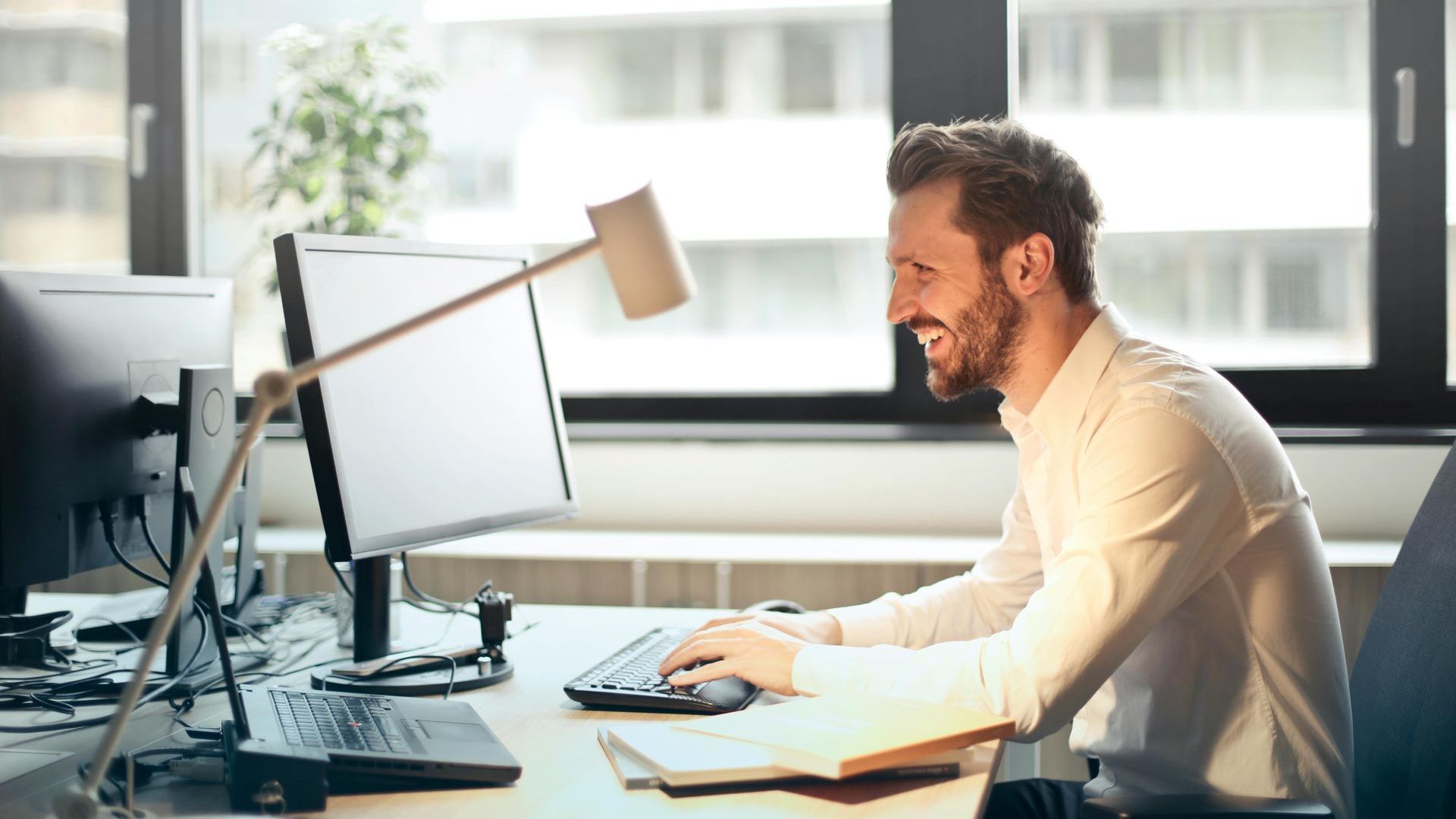 A man is sitting at a desk in front of a computer.