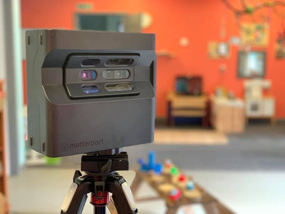 A camera is sitting on a tripod in a room.