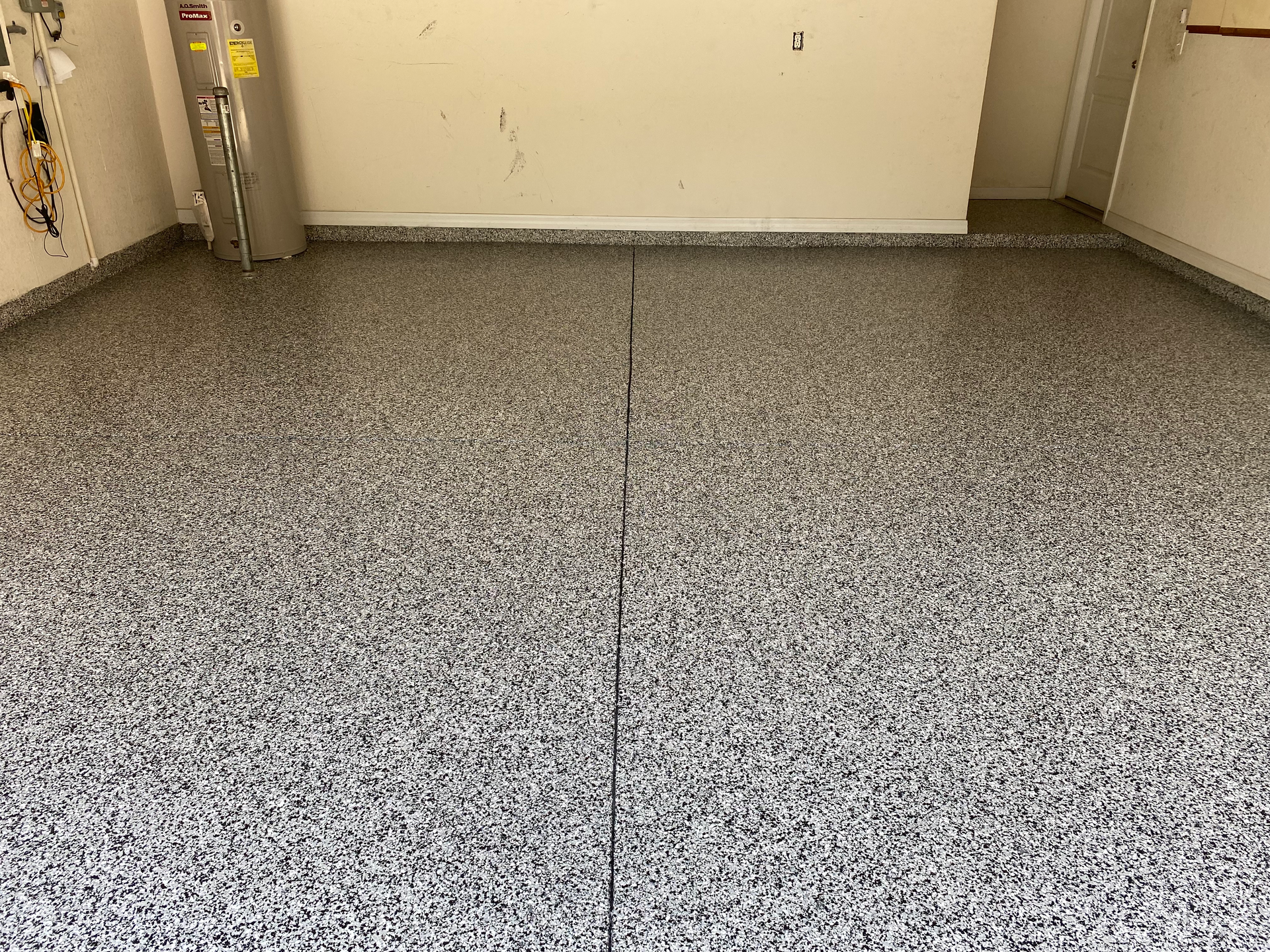 A garage with a gray floor and white walls.