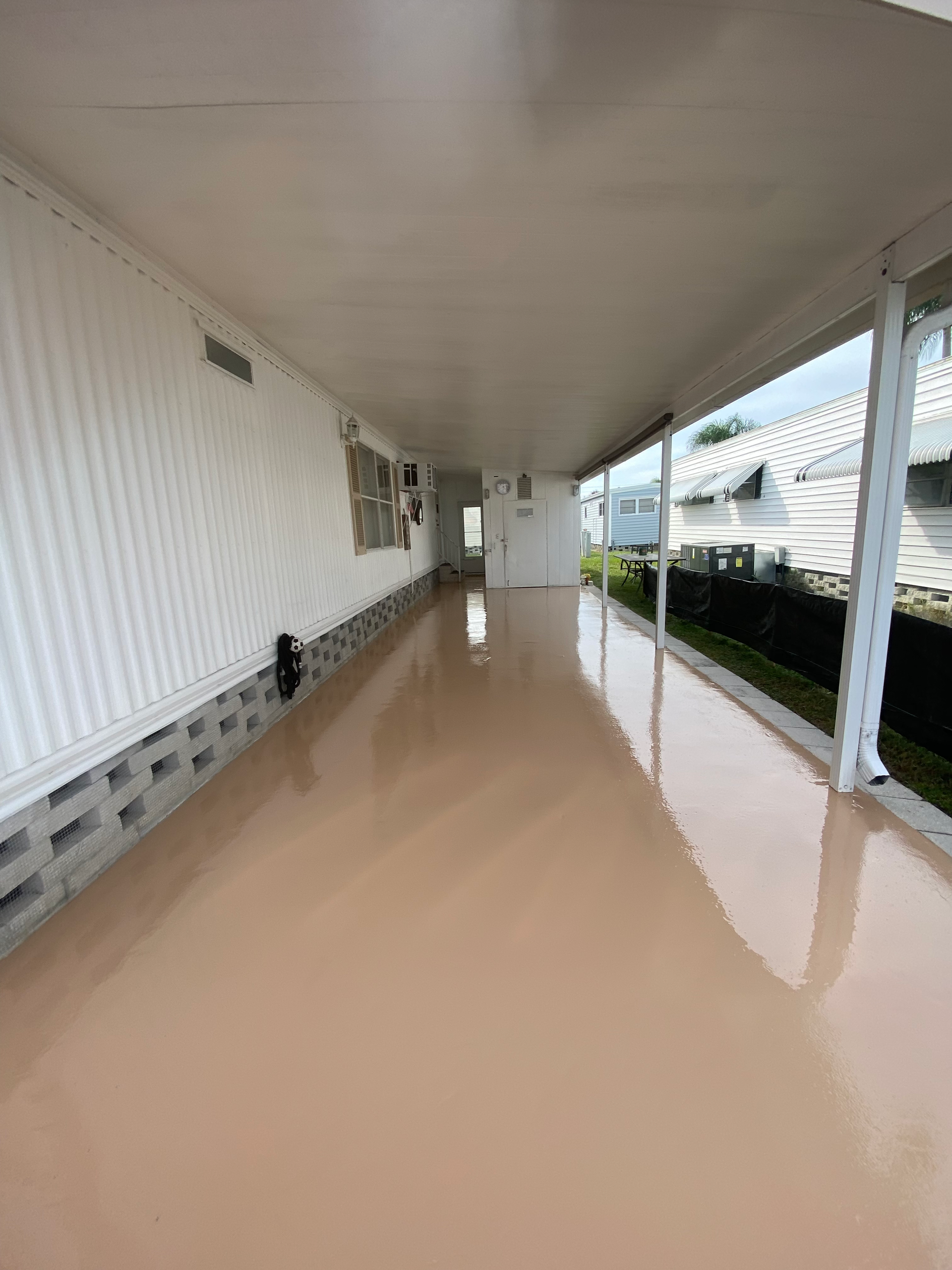 A long hallway with a covered walkway leading to a house.
