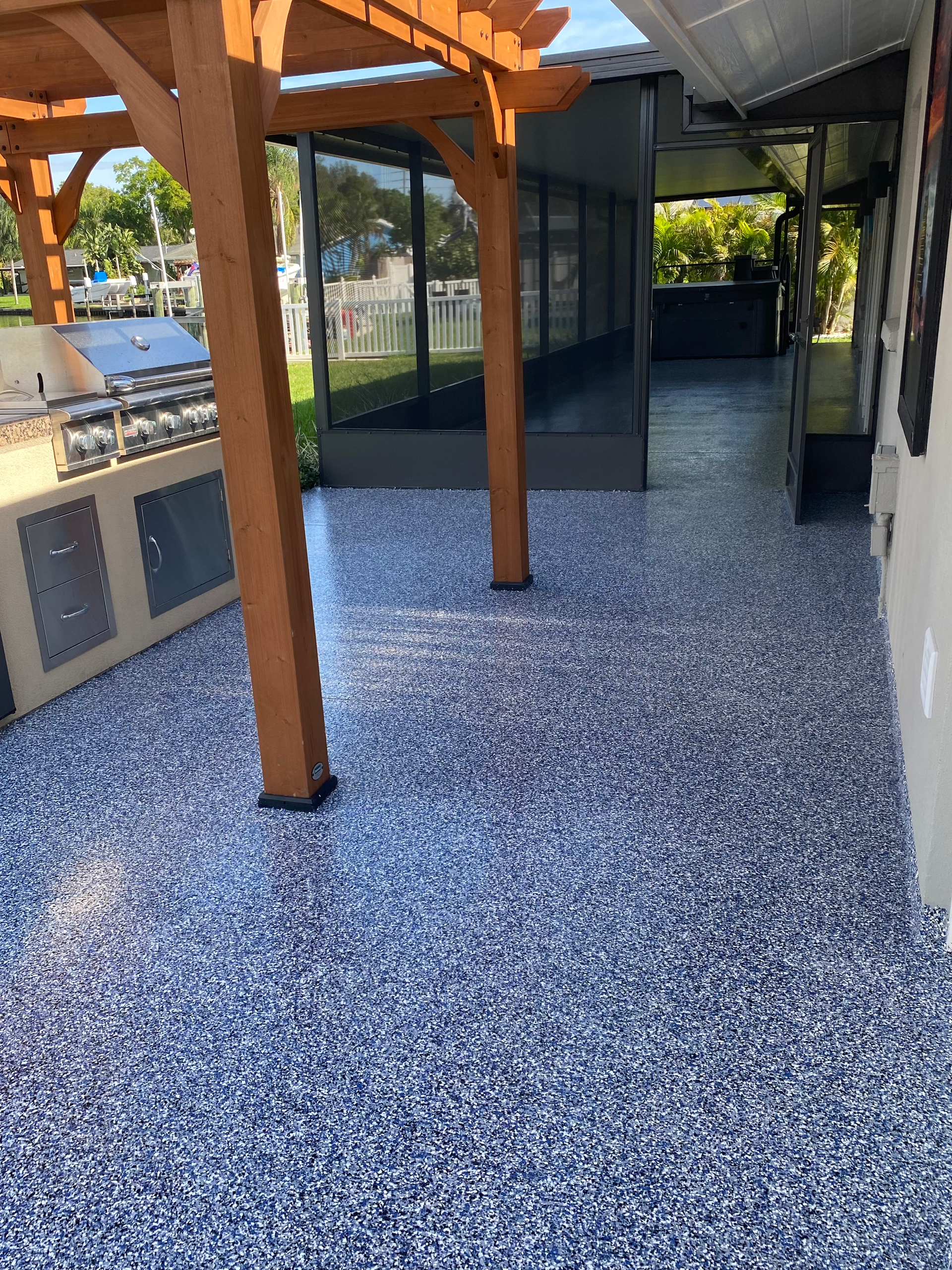 A patio with a pergola and a grill on it
