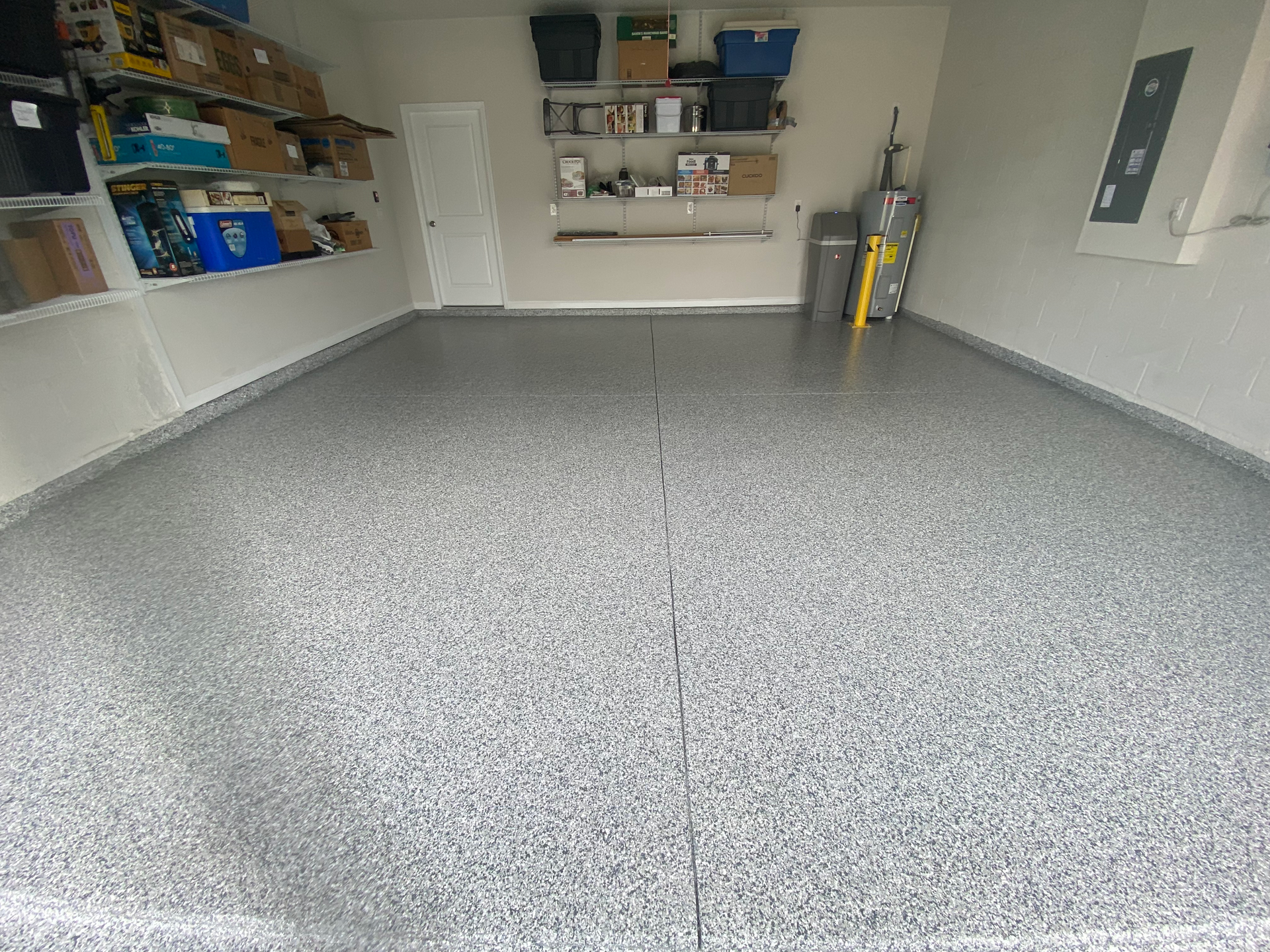 A garage with a gray floor and shelves.