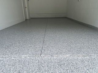 A garage with a gray floor and white walls.