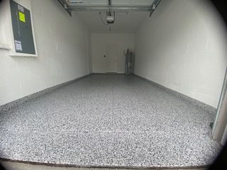 A garage with a gray floor and white walls.