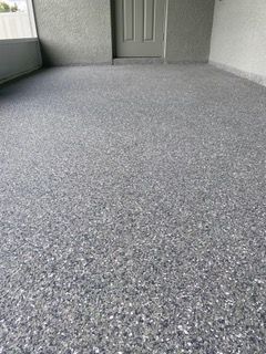 A room with a gray carpeted floor and a door.