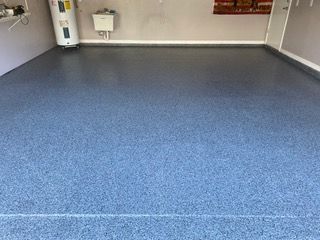 A garage with a blue floor and a water heater.