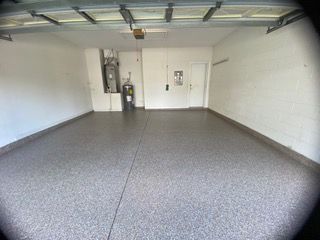An empty garage with a gray floor and white walls.