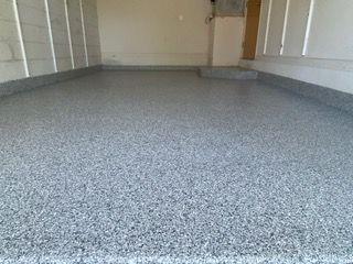 A garage with a gray floor and white walls.