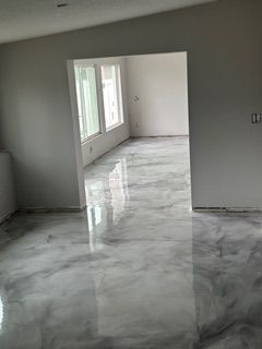 A living room with a marble floor and white walls.