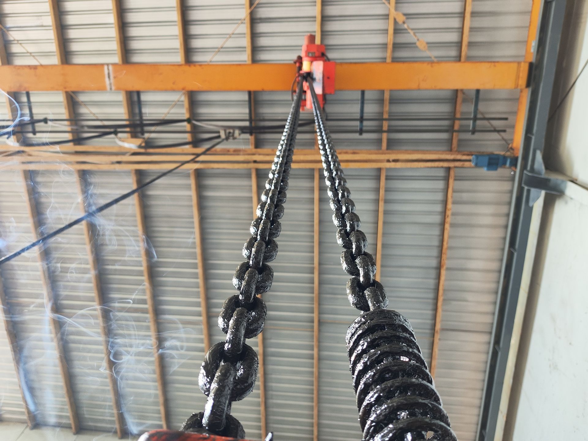 A large chain is hanging from the ceiling of a building.