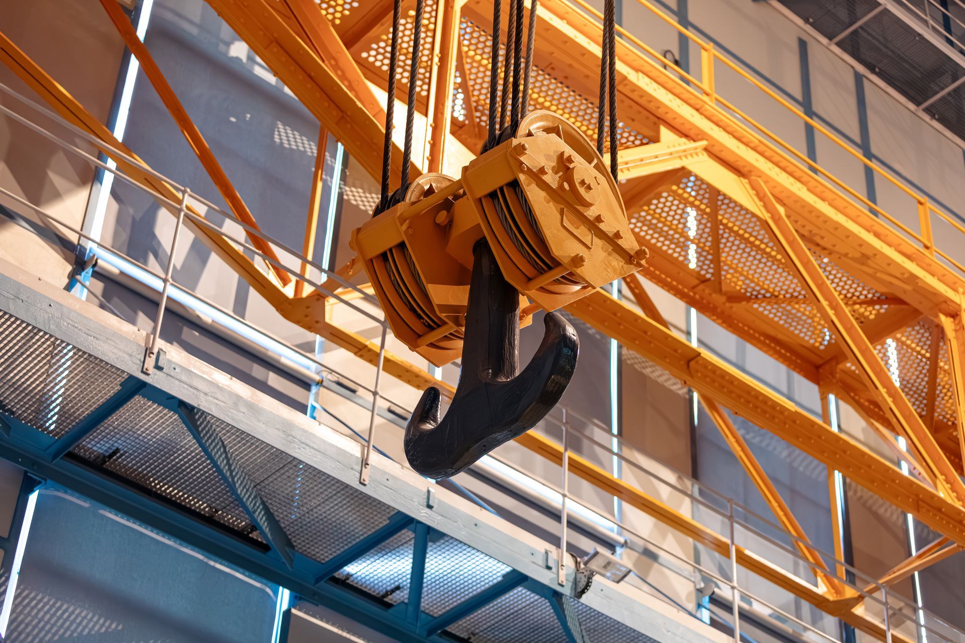 A crane hook is hanging from the ceiling of a building.