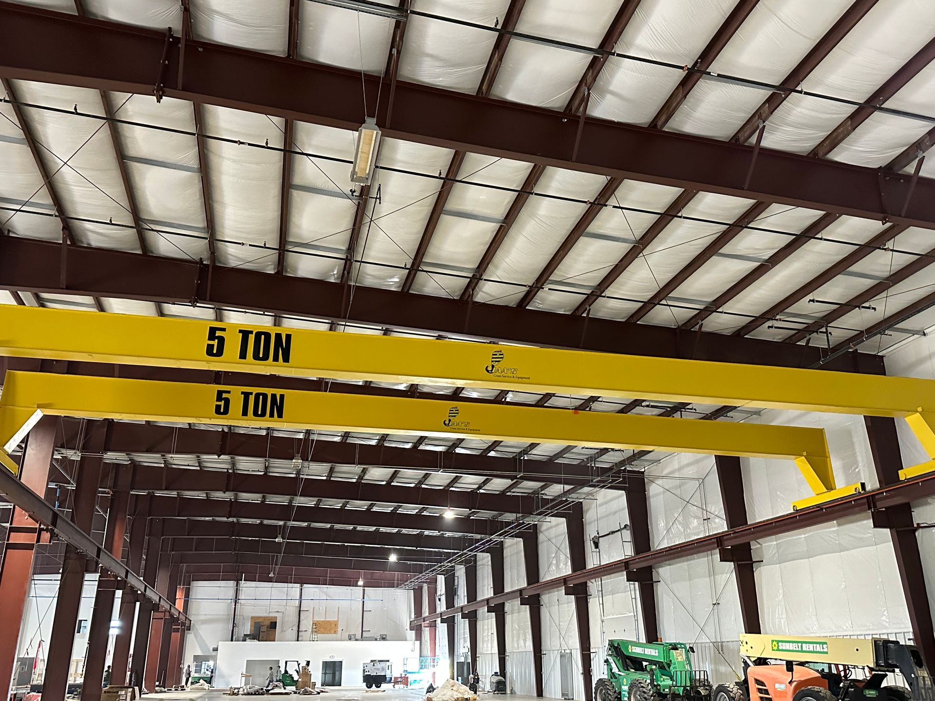 A large warehouse with a crane hanging from the ceiling.