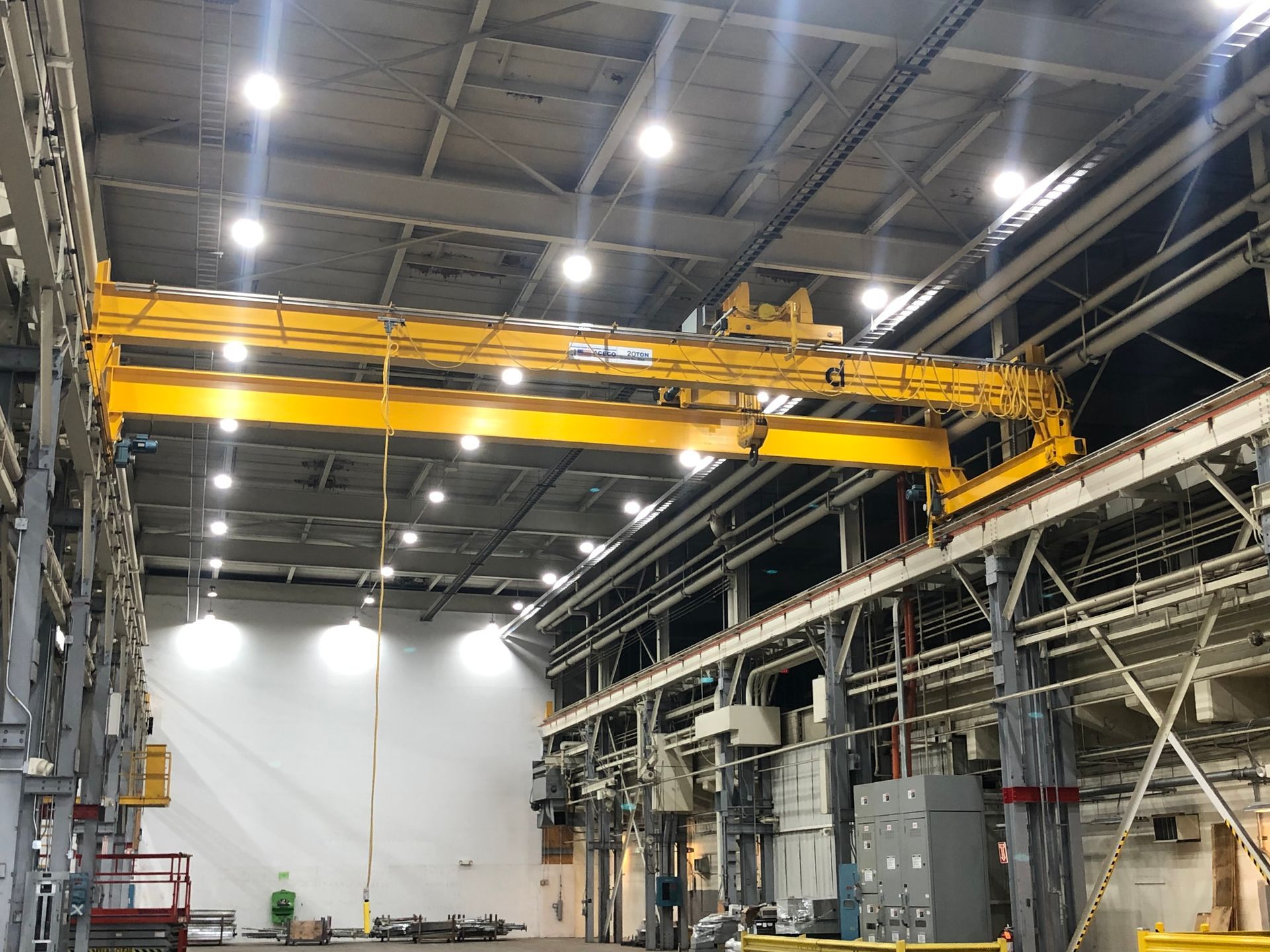 A large warehouse with a yellow crane in the middle of it