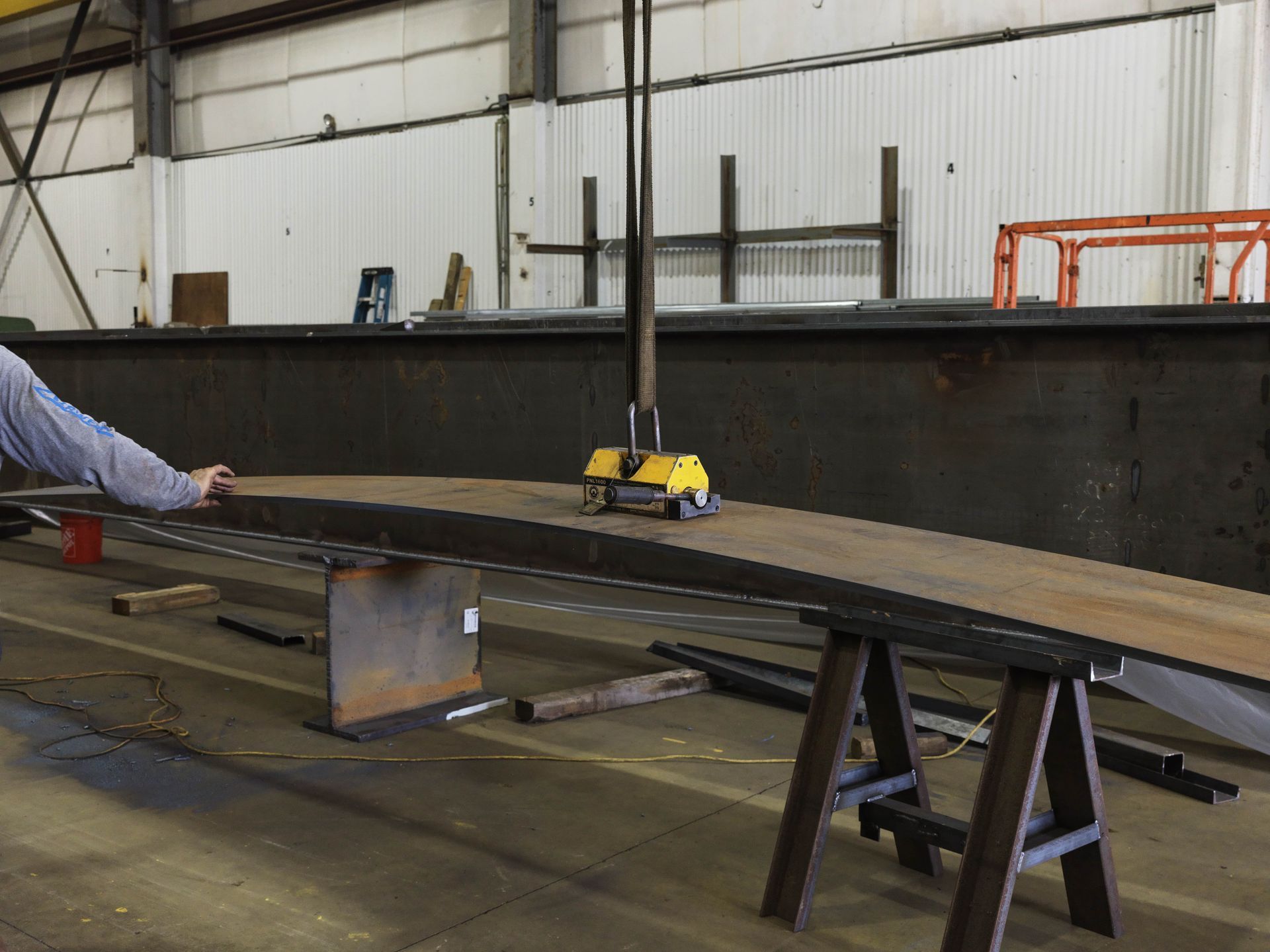 A man is working on a large piece of metal in a factory