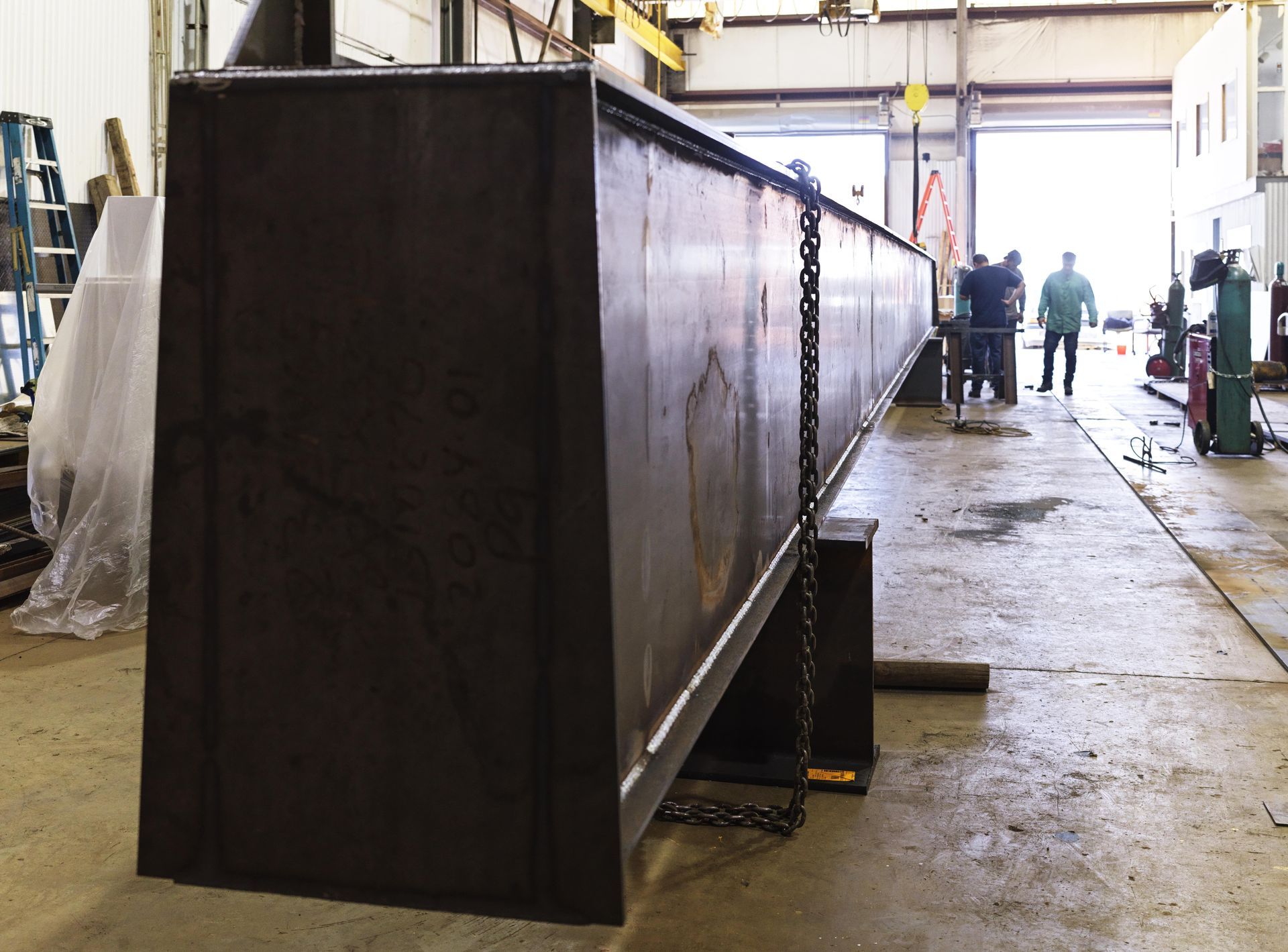 A large piece of metal is sitting on the floor in a factory