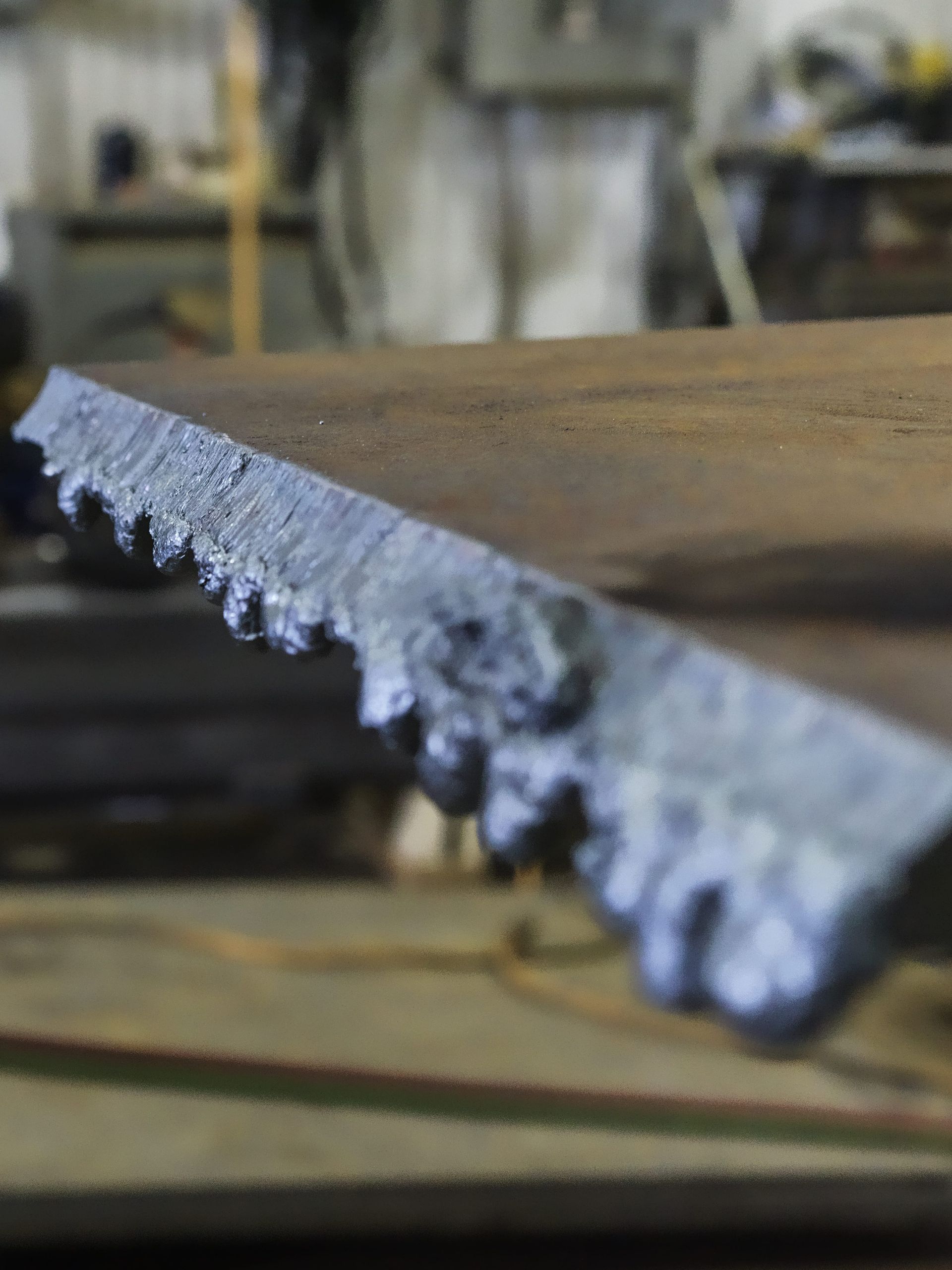 A saw is sitting on top of a wooden table.