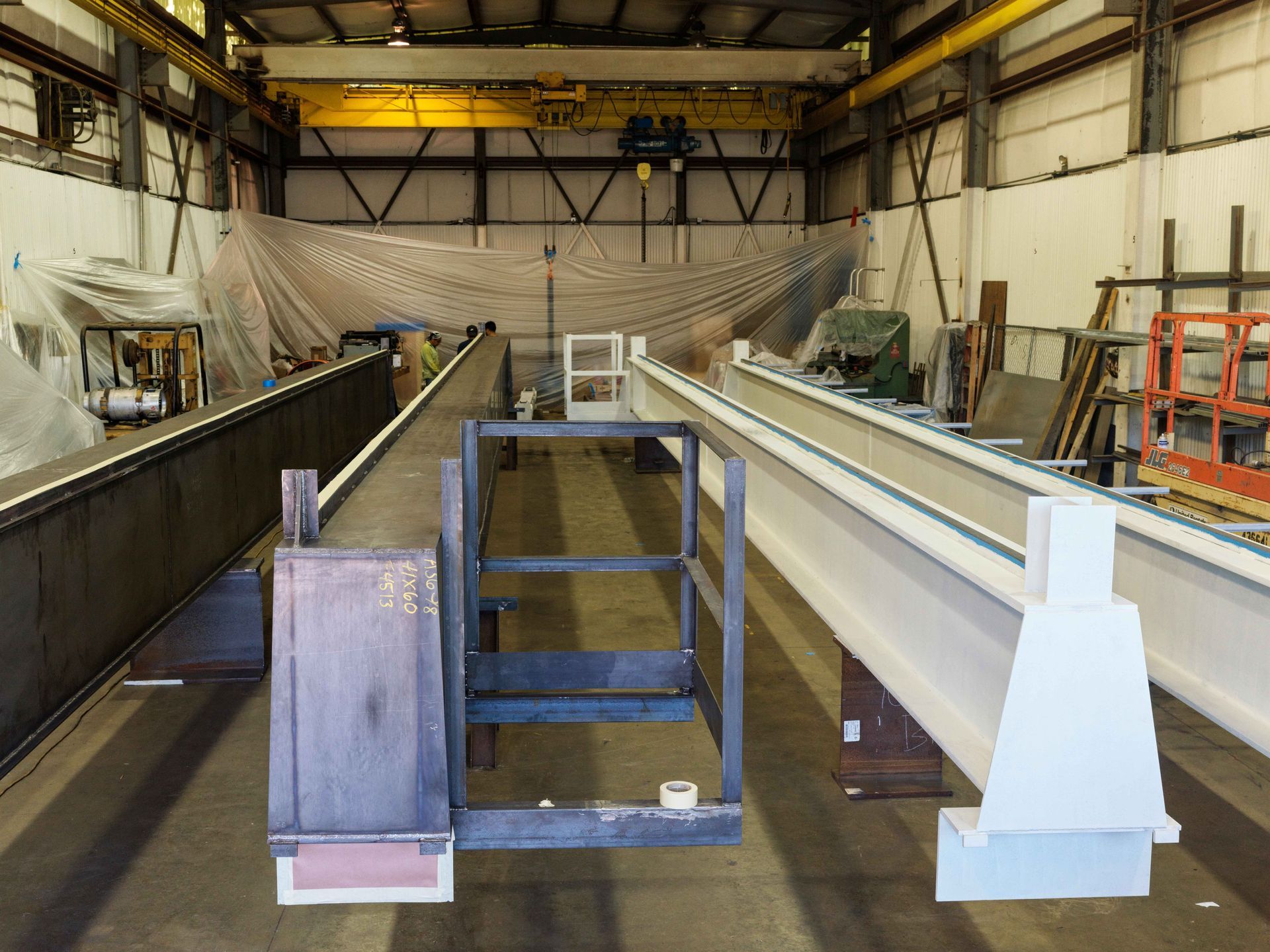 A large metal structure is being built in a factory