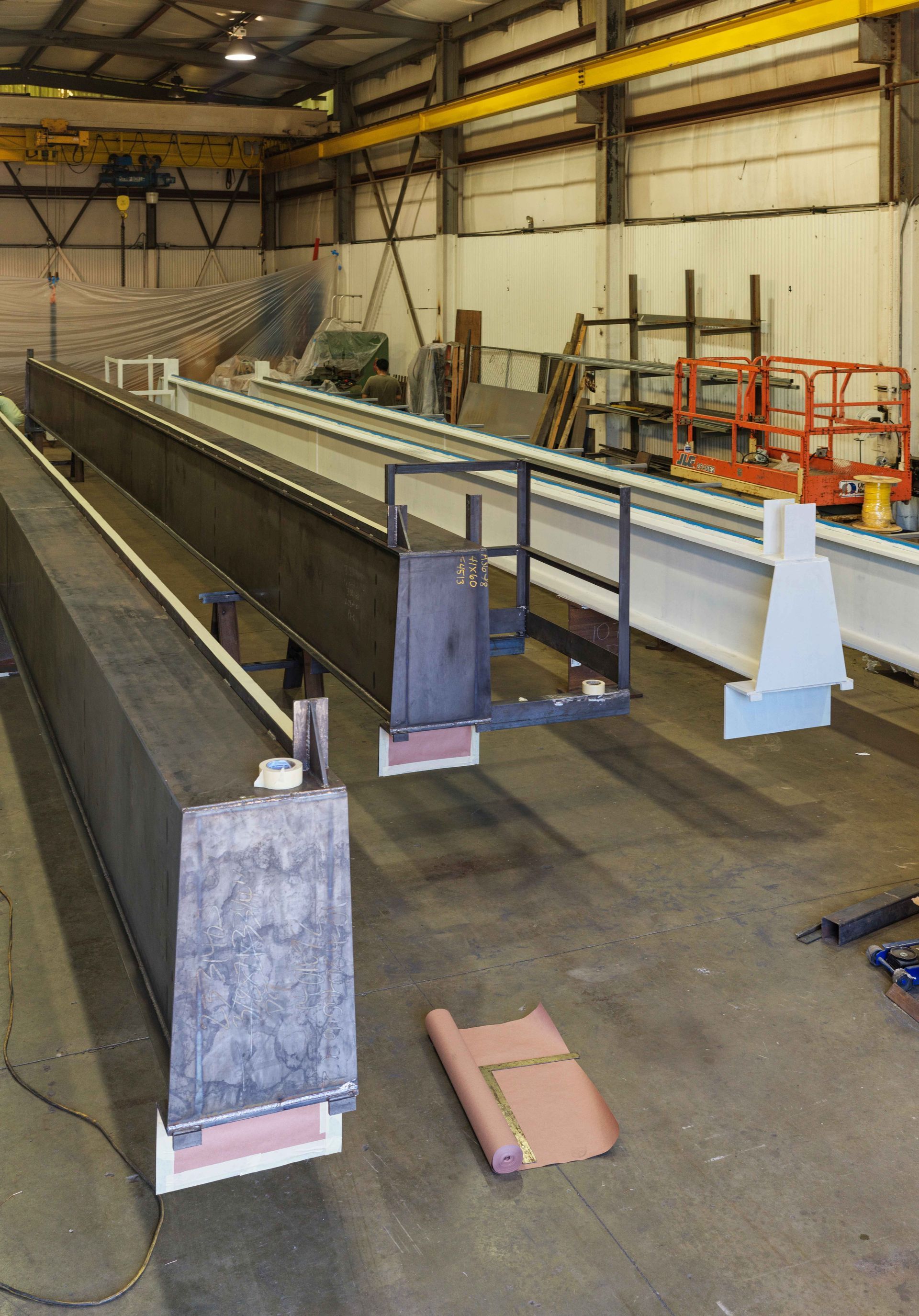 A large metal structure is being built in a factory