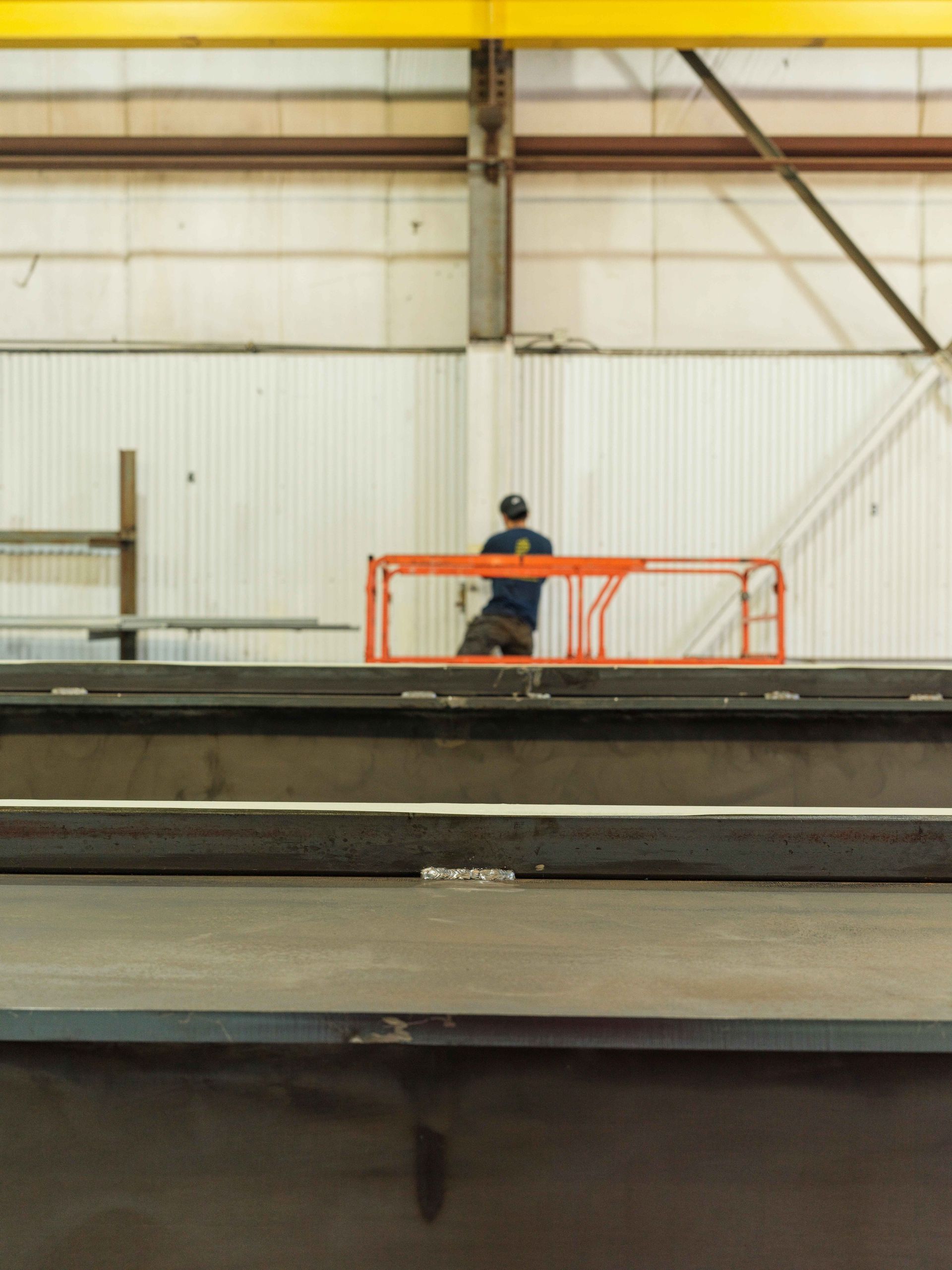 A man is standing on a ladder in a factory
