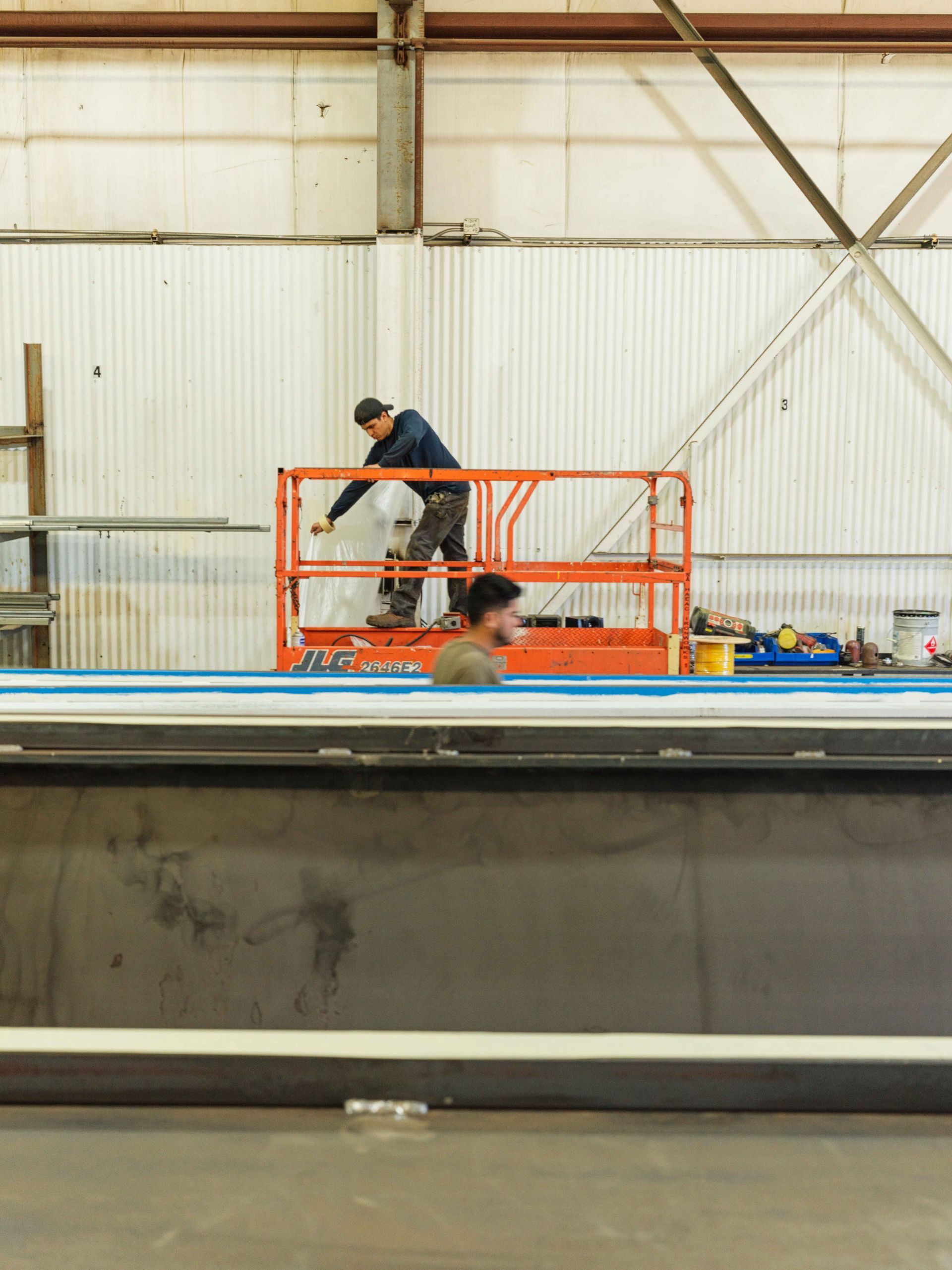 A man is standing on a lift in a factory.