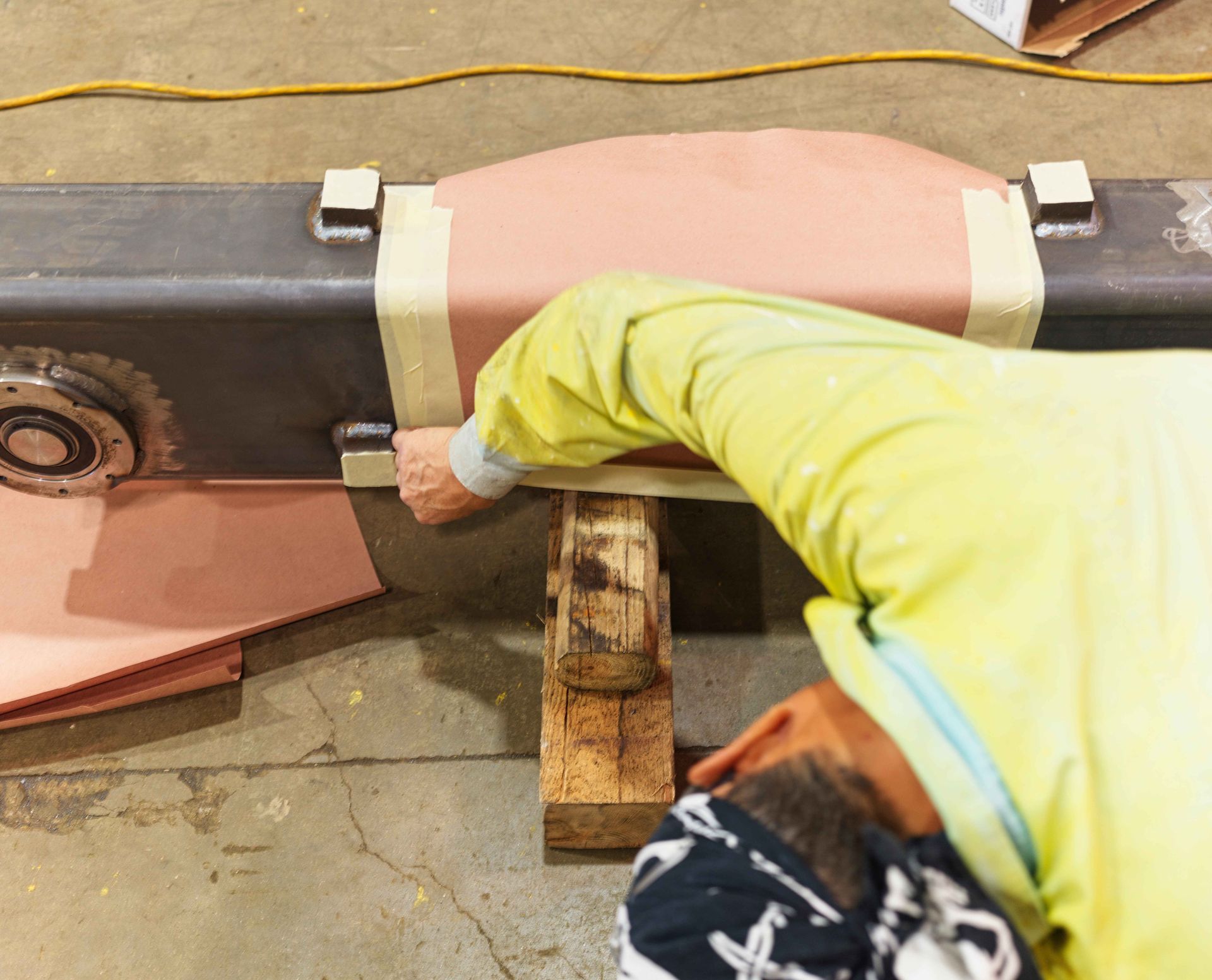 A man in a yellow shirt is working on a piece of equipment