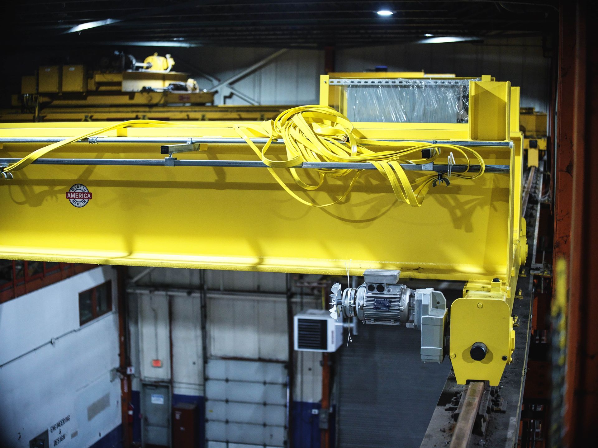 A large yellow crane is sitting inside of a building