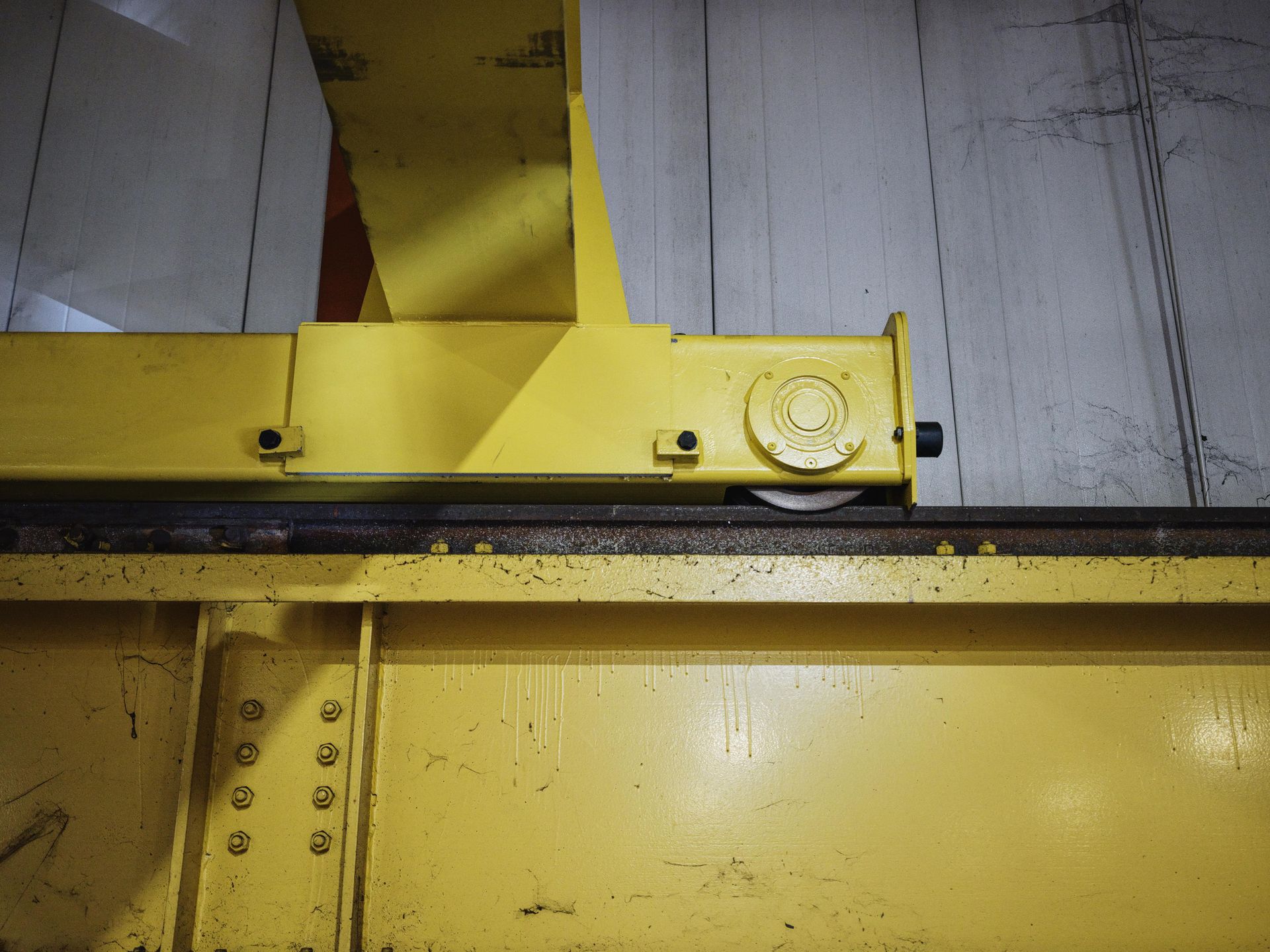 A close up of a yellow metal structure with a wheel on it