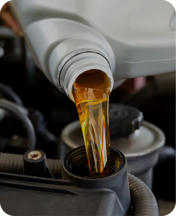 A bottle of oil is being poured into a car engine. | Japanese Car Care
