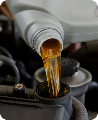 A bottle of oil is being poured into a car engine. | Japanese Car Care