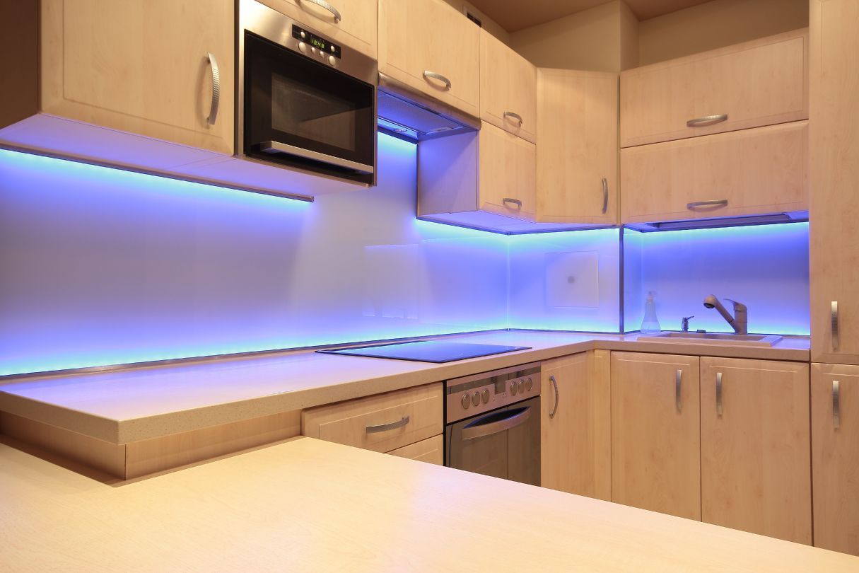 A white kitchen with blue under cabinet LED lighting 