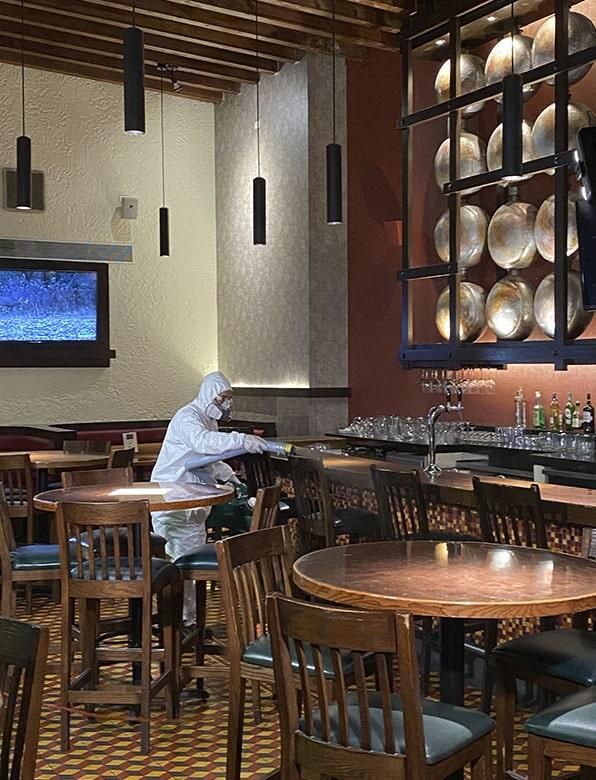 Un hombre con un traje blanco está sentado en una mesa en un restaurante.