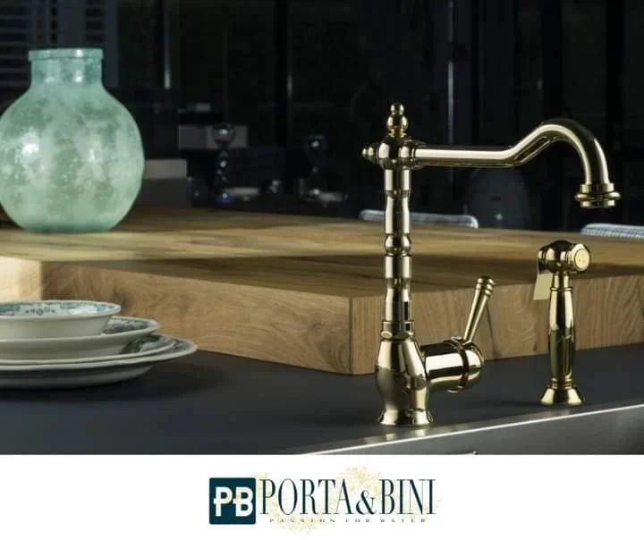 Sul bancone della cucina, accanto a un vaso verde, c'è un rubinetto d'ottone