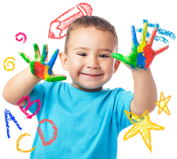 Happy child with hands covered in colorful paint, smiling and surrounded by crayon drawings.