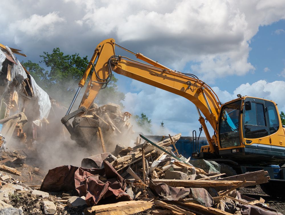 A Worker Operating a Backhoe for Demolition