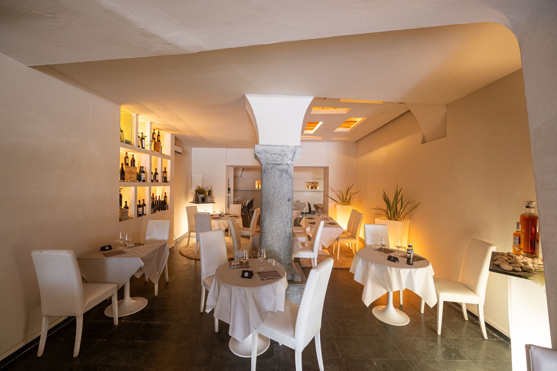 Un ristorante con tavoli e sedie e un pilastro al centro