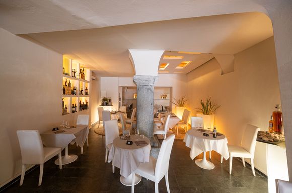 Un ristorante con tavoli e sedie e un pilastro al centro